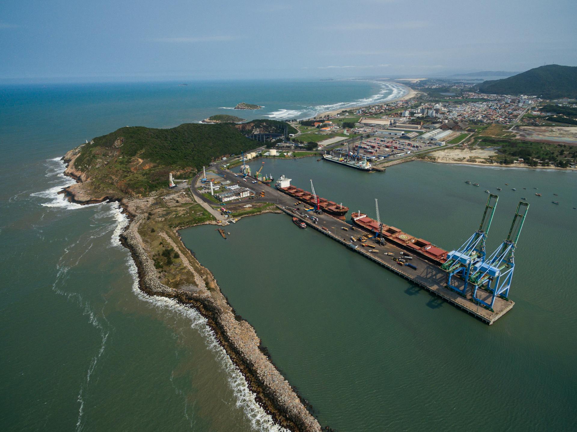 Aerial shot of Imbituba port showing docks, cranes, and coastline in Brazil.