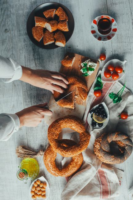 Flat lay of traditional Turkish simit with tomatoes and tea, embodying İstanbul's culinary culture.