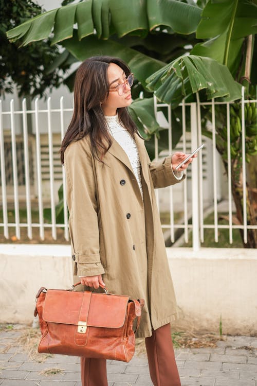 Young Elegant Woman Walking on the Sidewalk in City 