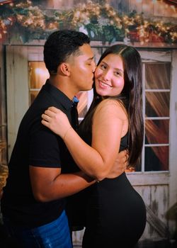 Joyful couple embracing and smiling in a festive setting indoors.