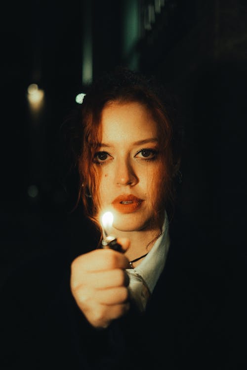 Woman Holding a Lighter in the Dark 