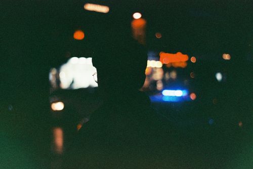 Free A silhouette of a person at night with blurred urban lights creating a mysterious atmosphere. Stock Photo