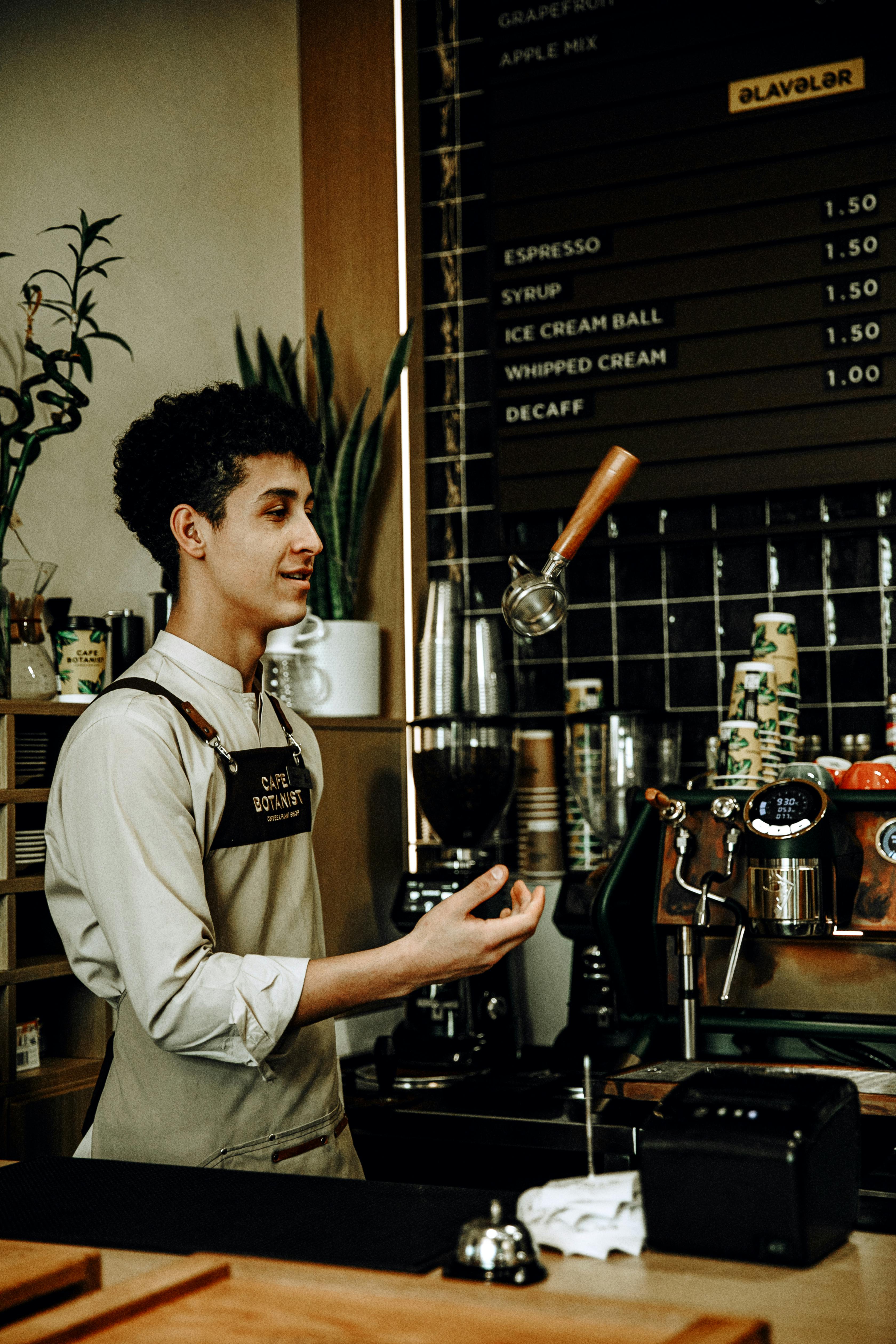 man in apron working at cafe