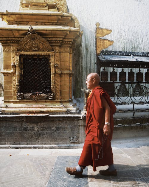 A Monk Walking in front of a Temple 