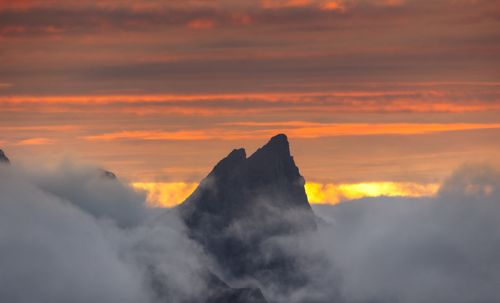 Free A breathtaking view of a mountain peak surrounded by mist at sunset in Norway's Lofoten Islands. Stock Photo