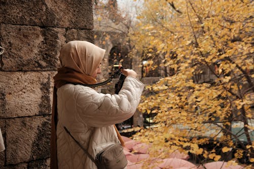 Free Woman with Brown Scarf Taking Photo of Park in Autumn Stock Photo