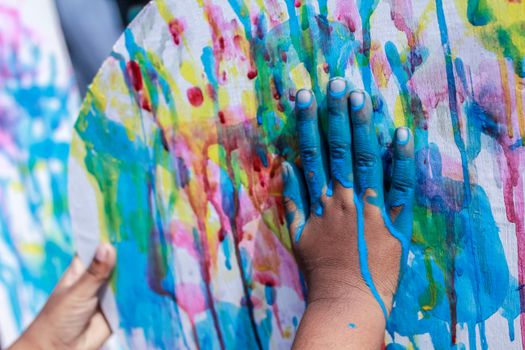 A vibrant splash of colors as hands paint on canvas, showcasing creativity in Dhaka.