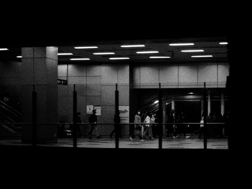 Free Black and white photo capturing commuters walking through an urban subway station in Jakarta. Stock Photo