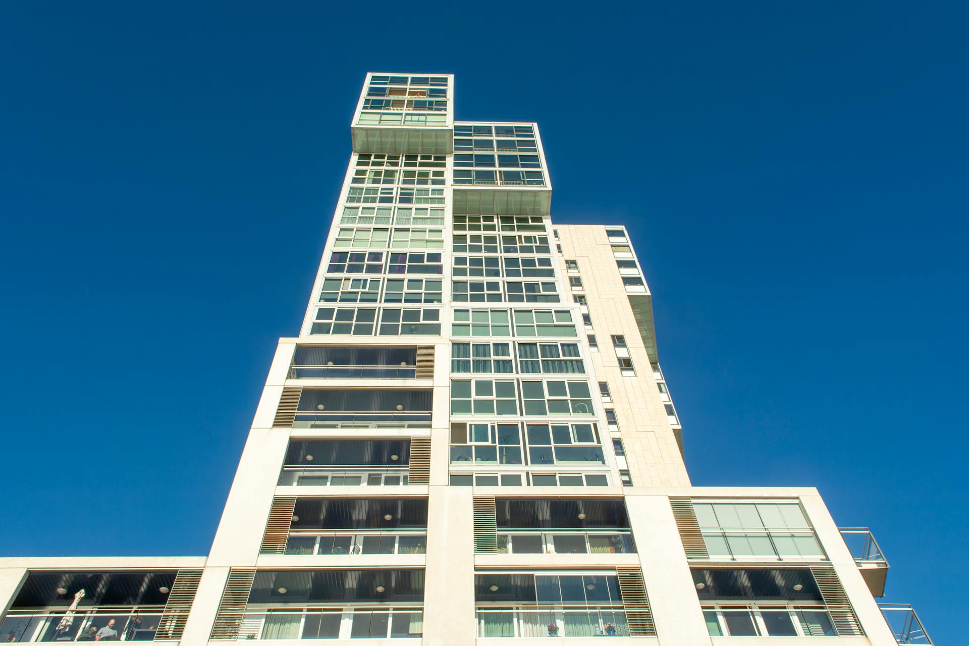 A striking modern building in Rotterdam against a vivid blue sky, showcasing architectural elegance.