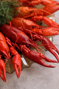 Close-up of vibrant red boiled crayfish on a plate, perfect for seafood lovers.