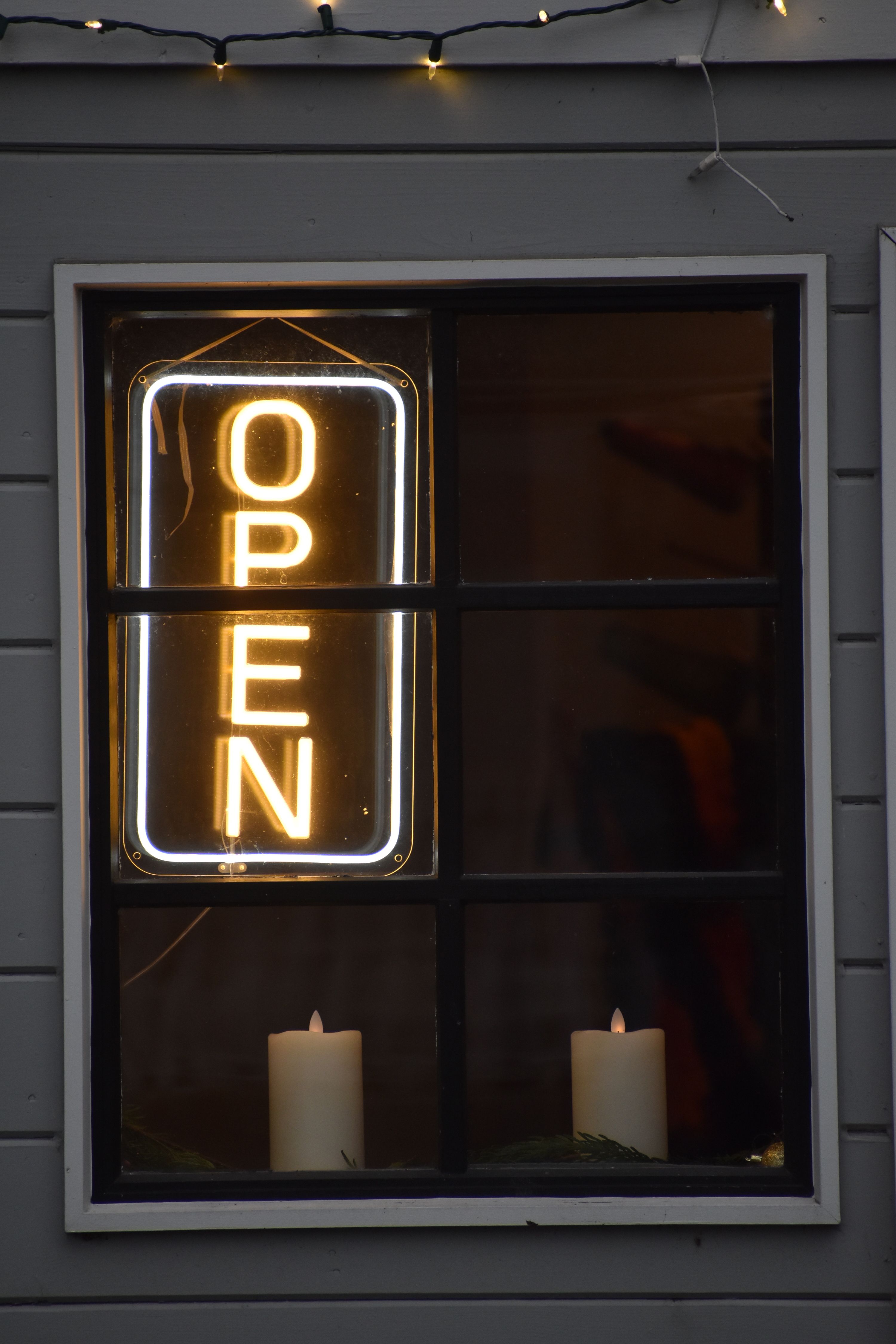 A Neon Sign and Candles in a Window · Free Stock Photo