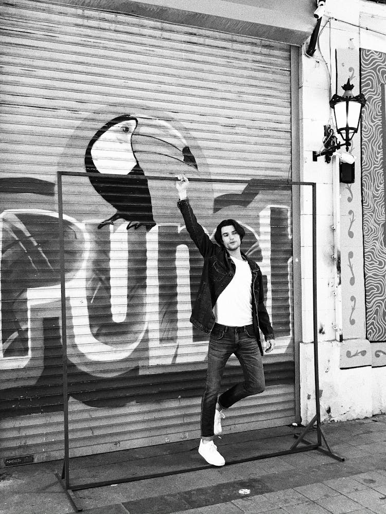 Man Standing By Graffiti On Wall 