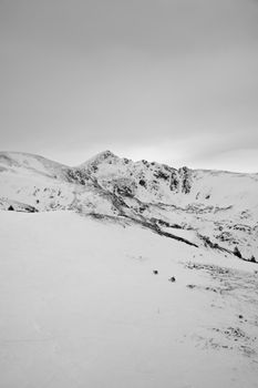 A breathtaking view of snow-covered mountains under an overcast sky, perfect for winter themes.