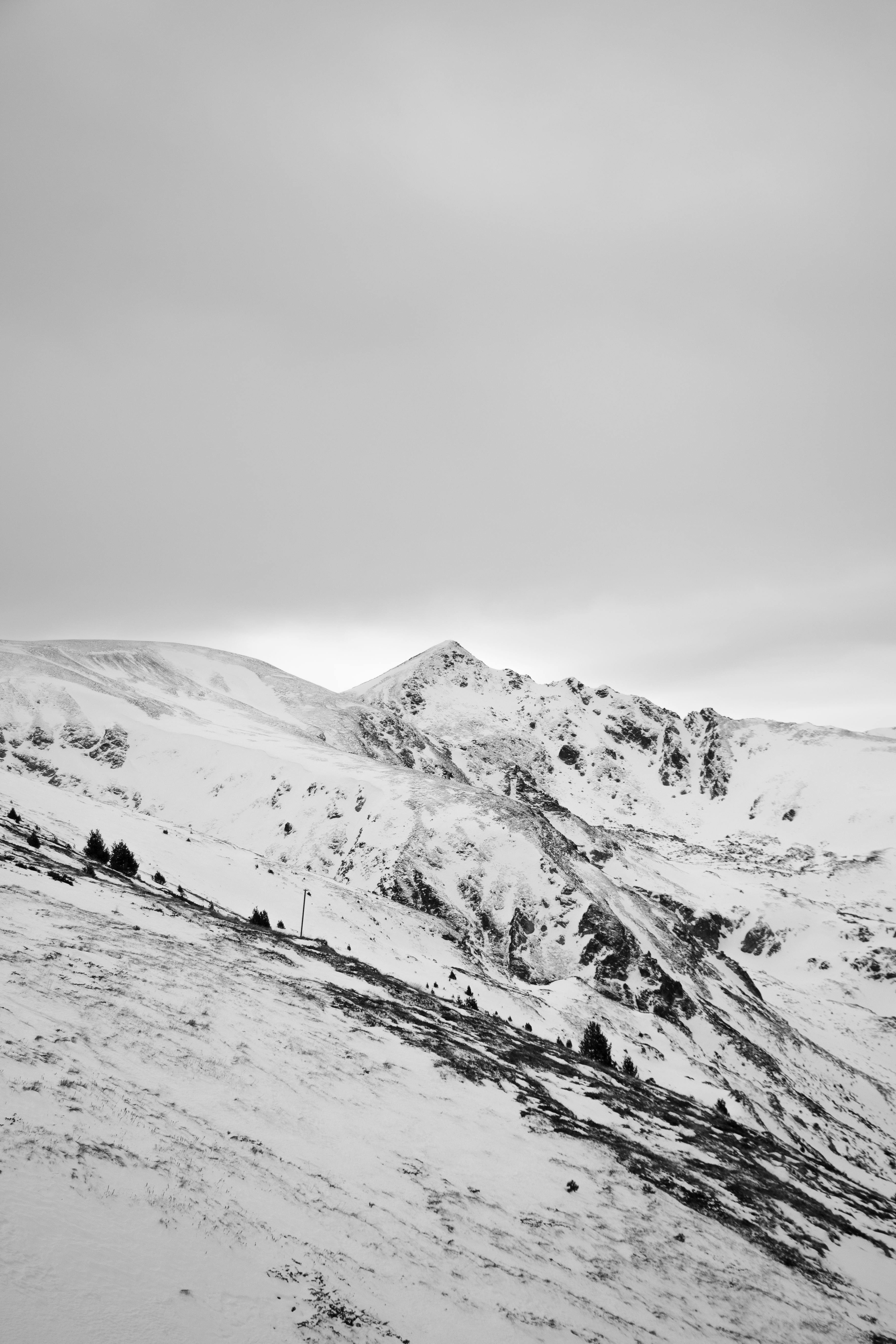 Serene black and white mountain peak covered in snow, evoking winter tranquility.