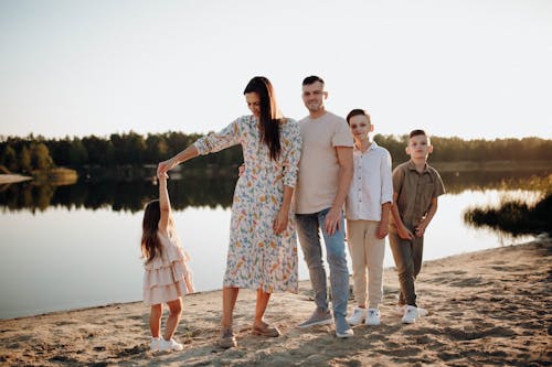 Serene Family Standing on Beach by Lake