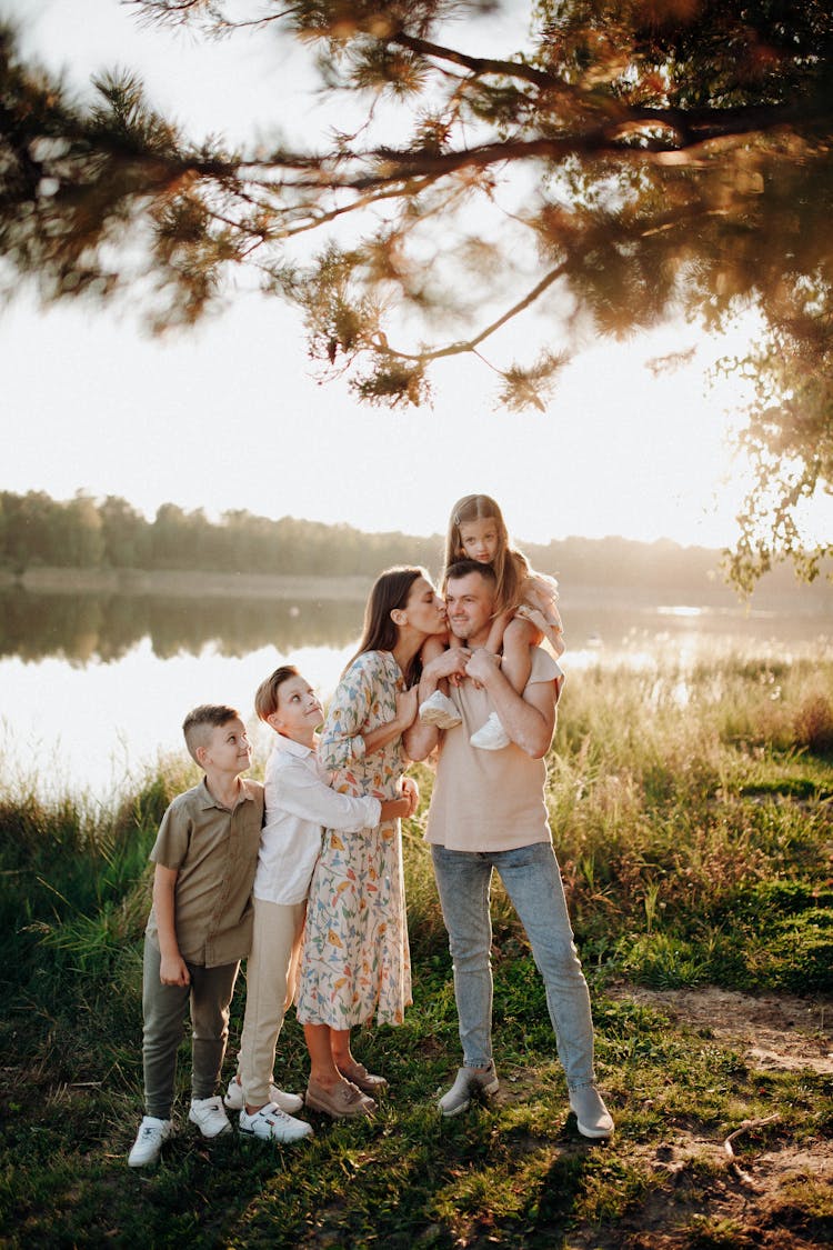 Joyful Family Standing Beside Lake