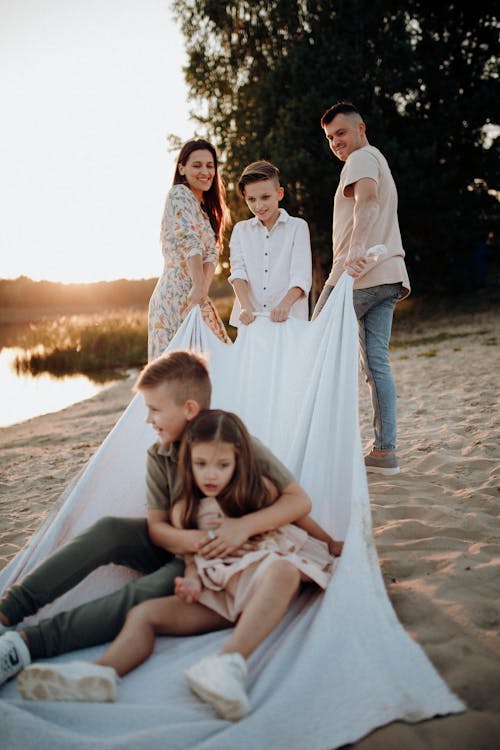 Family Posing with White Sheet on Beach