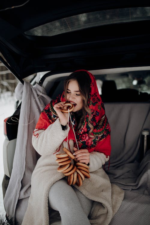 Brunette Woman with Red Headscarf Eating Traditional Donut