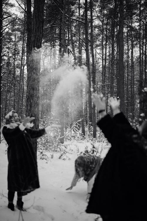 Women Throwing Up Snow in Forest