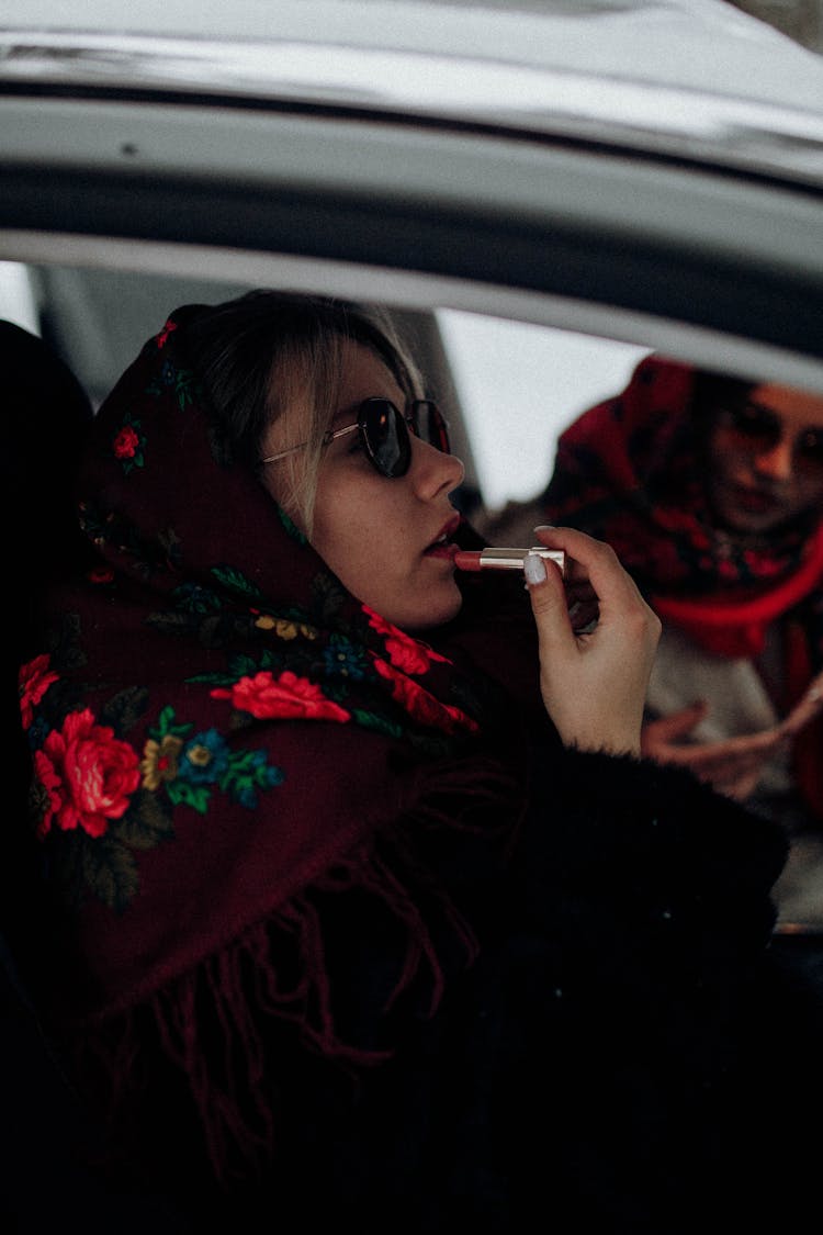 Woman Putting On Lipstick In Car