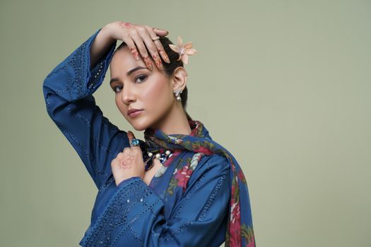 A stylish portrait of a young woman in traditional embroidered attire, exuding elegance and grace.