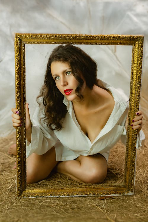 Model Wearing Red Lipstick and White Blouse Posing with Frame