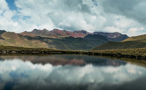 Scenic View of a Lake and Mountains under a Cloudy Sky 