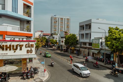 Free Lively street view in Ho Chi Minh City showcasing vibrant urban life with cars and scooters. Stock Photo