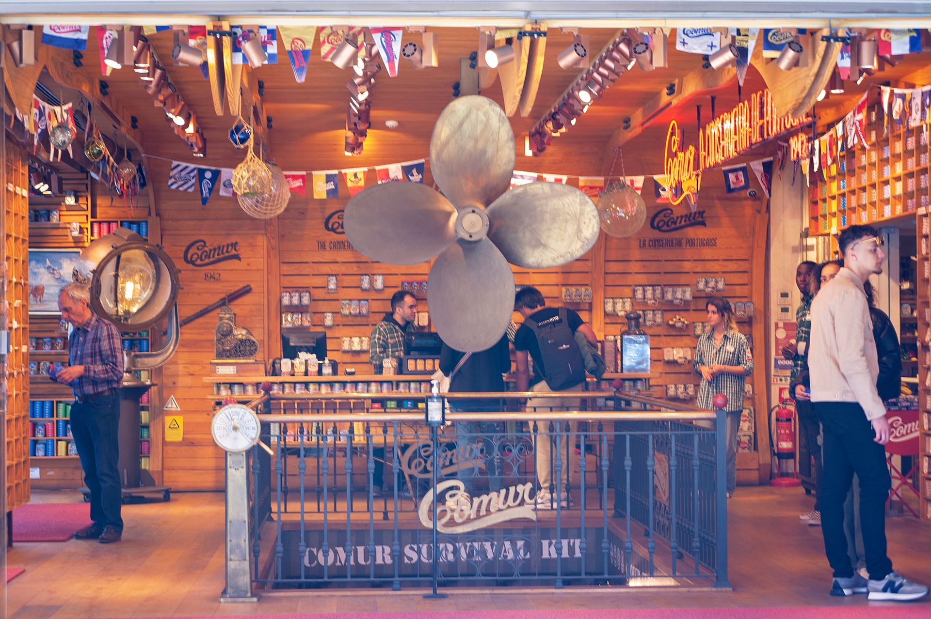 A vibrant nautical themed store interior with flags and a large propellor decoration.