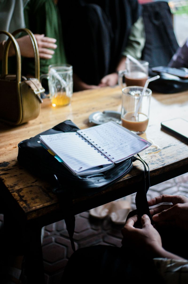 Adults conversing at a table with notebooks.