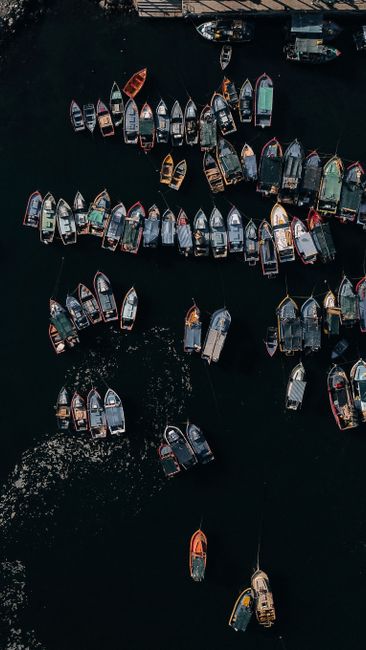 Stunning aerial shot of numerous boats docked at a busy harbor, showcasing maritime activity.