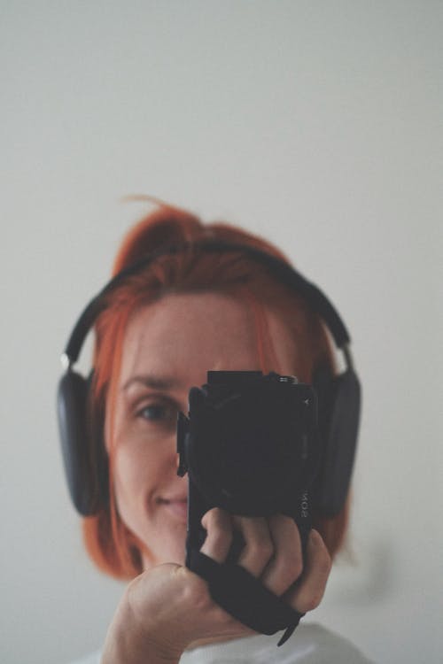 Woman in Headphones Taking Pictures with Camera