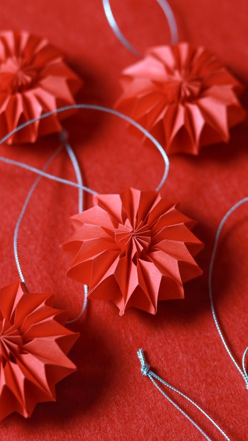 Free Vibrant red paper ornaments on a matching background, perfect for holiday decor. Stock Photo