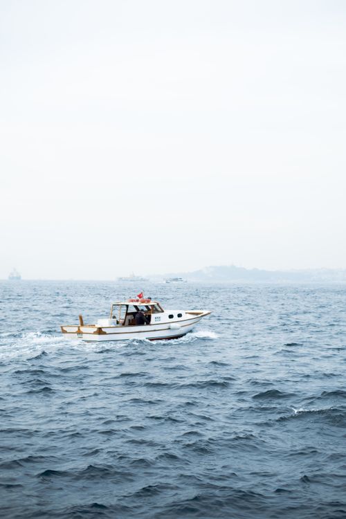 Free A motorboat cruising through foggy waters in Istanbul, Türkiye with a visible skyline. Stock Photo