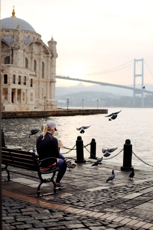 Woman Sitting on Sea Shore near Ortakoy Mosque in Istanbul