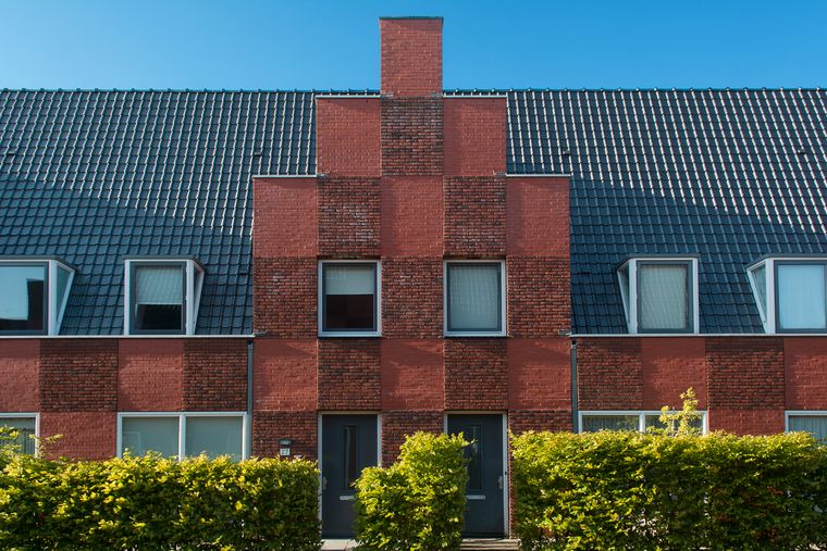 Brick townhouse facade with clipped hedge — photo by Jan van der Wolf on Pexels