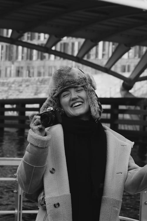 Smiling Woman in Fur Hat Holds Camera