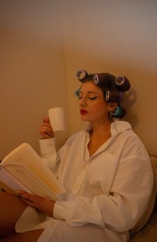 Woman in White Shirt Sitting with Hair Rollers