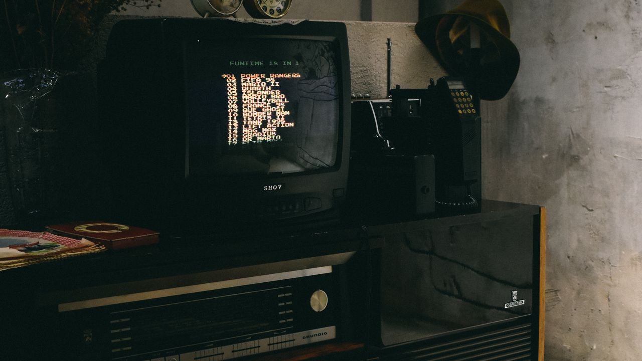 Vignette fixe : poste de jeu rétro avec téléviseur cathodique, console et manettes sur une table.