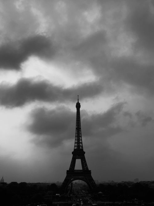 Free Black and white silhouette of the Eiffel Tower under a dramatic, cloudy sky in Paris, France. Stock Photo