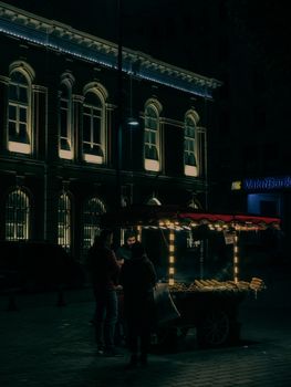 A street food vendor at night in İstanbul, Türkiye, illuminating the dark city streets.