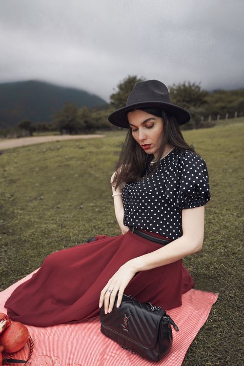Free Elegant woman posing during a picnic in a scenic meadow, exuding grace and fashion. Stock Photo