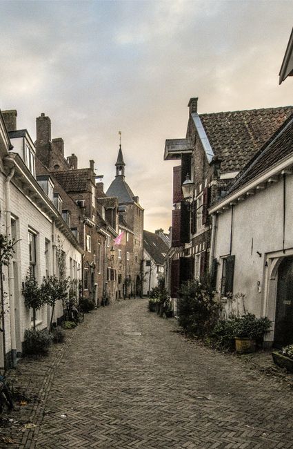A narrow, historic street with classic Dutch brick architecture in Amersfoort, Netherlands.