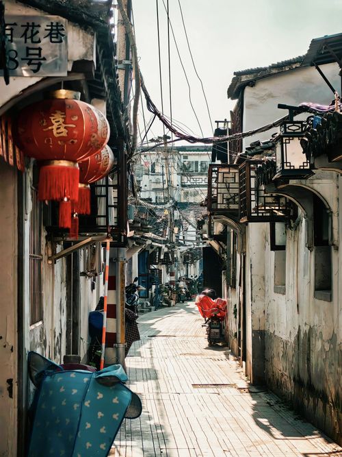 Free Charming alleyway adorned with red lanterns showing traditional Asian architecture and character. Stock Photo