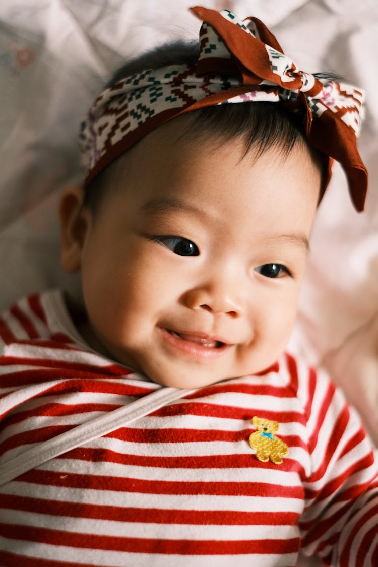 Little Girl Wearing Stripped Shirt Lying In Bed 