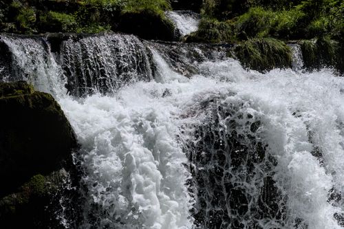 Free Majestic waterfall cascading through lush greenery in Brienz, Switzerland's serene forest landscape. Stock Photo