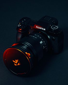 Fujifilm camera with lens showcasing photography gear on a dark backdrop.