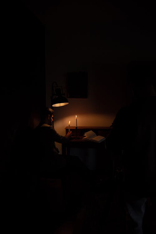 Sitting Man by Desk Illuminated with Candles