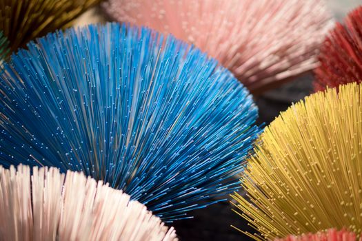 A close-up of colorful decorative stick arrangements in blue, pink, and yellow, creating a vibrant artistic display.