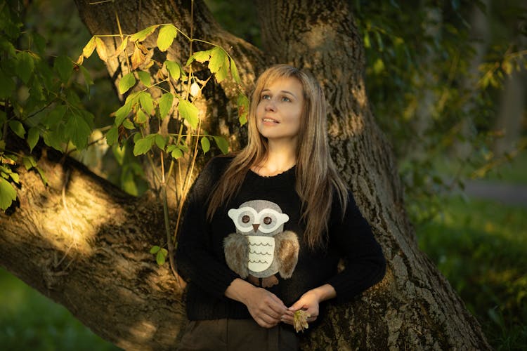 Blonde Woman In Sweatshirt Posing By Tree